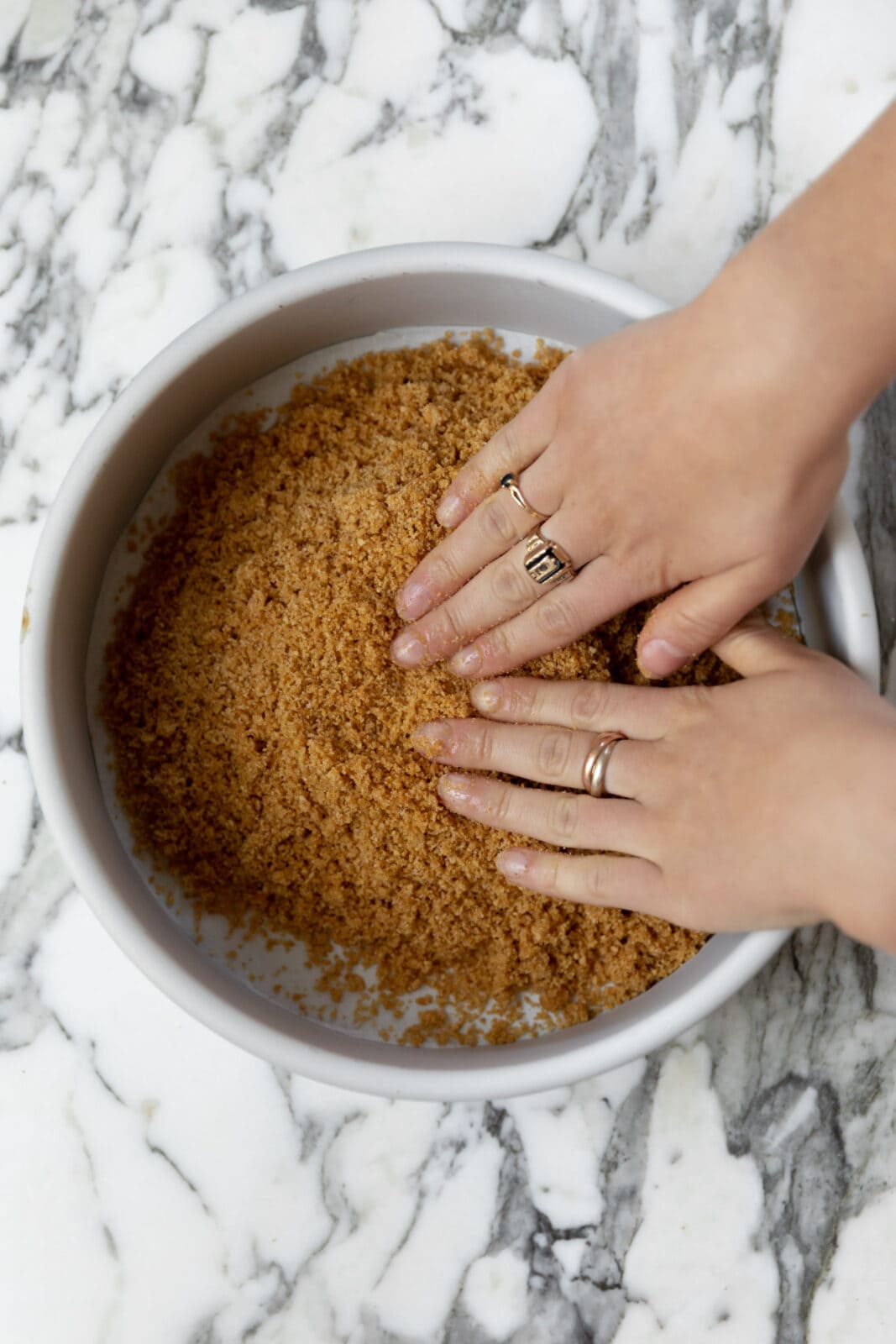 packing graham cracker crust into a pan