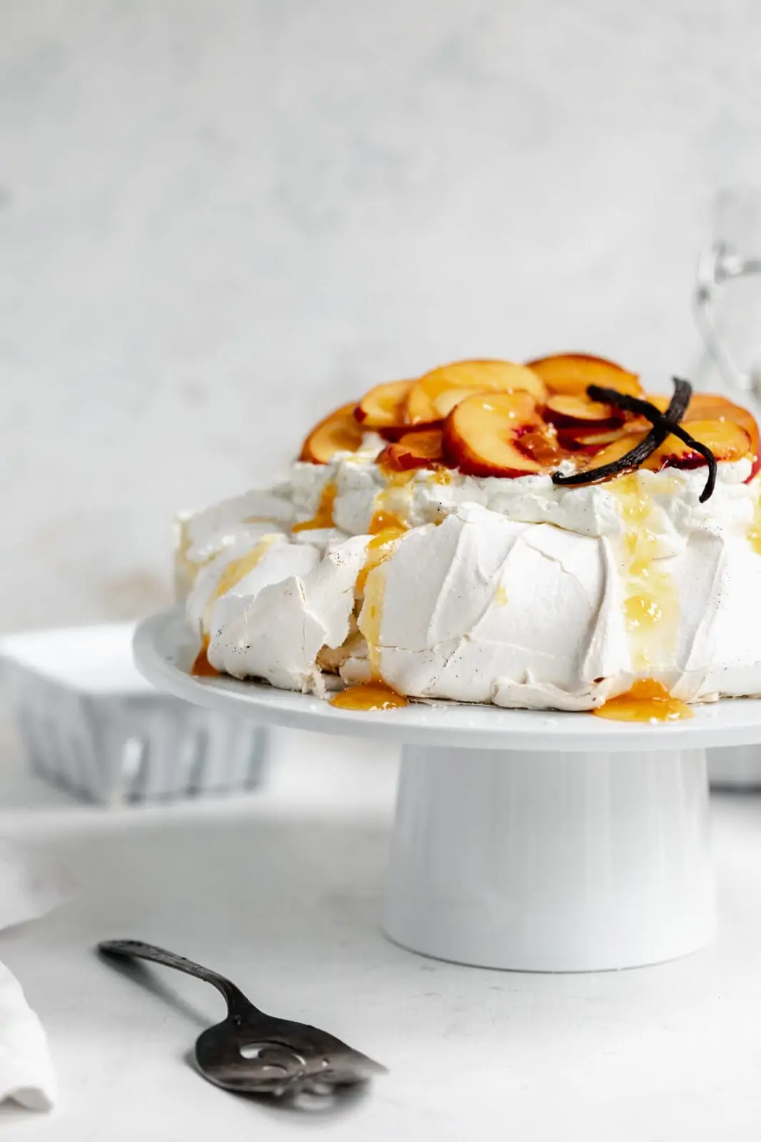 peaches and cream pavlova on cake stand