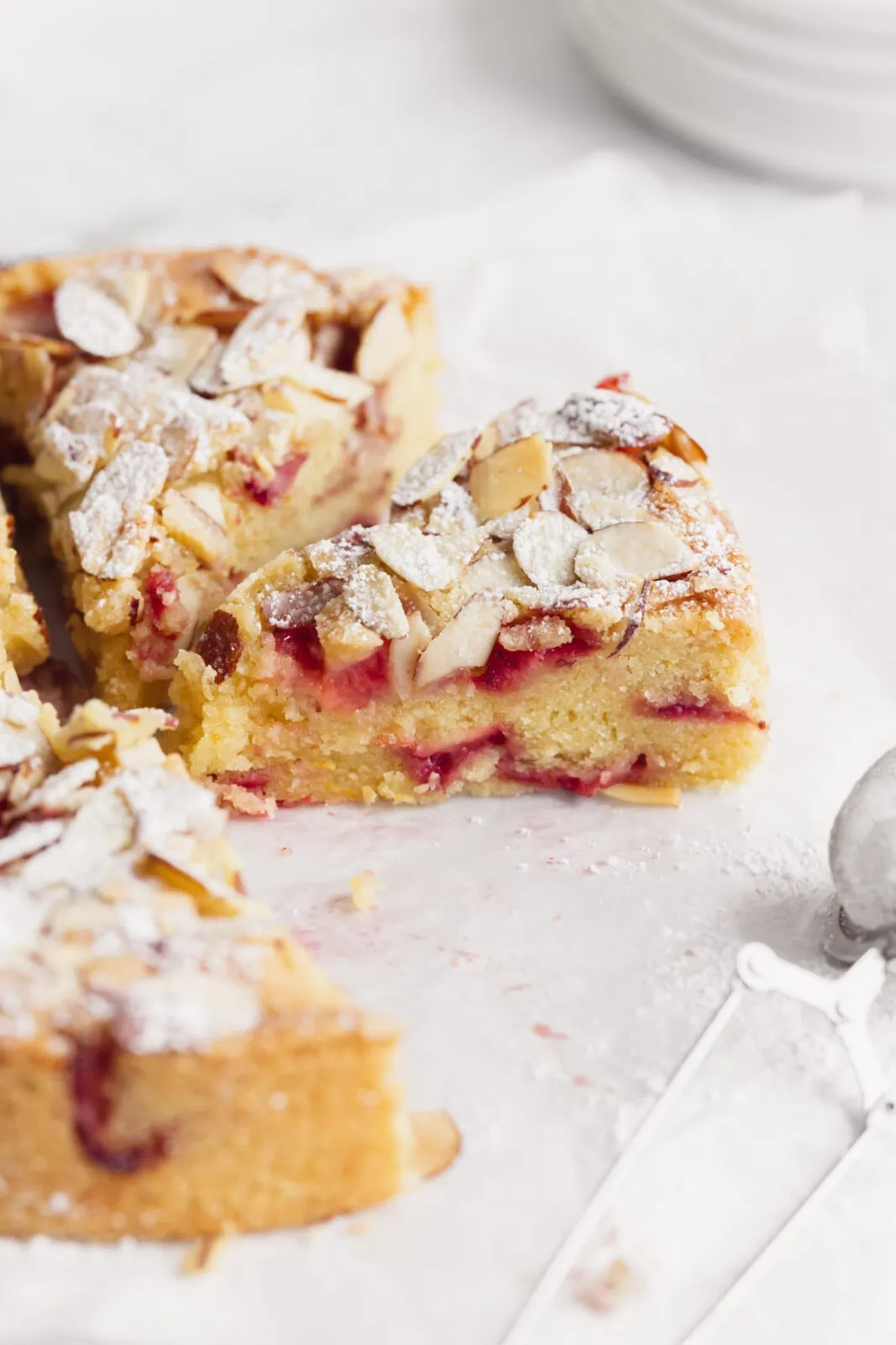 strawberry almond cake with slivered almonds and powdered sugar