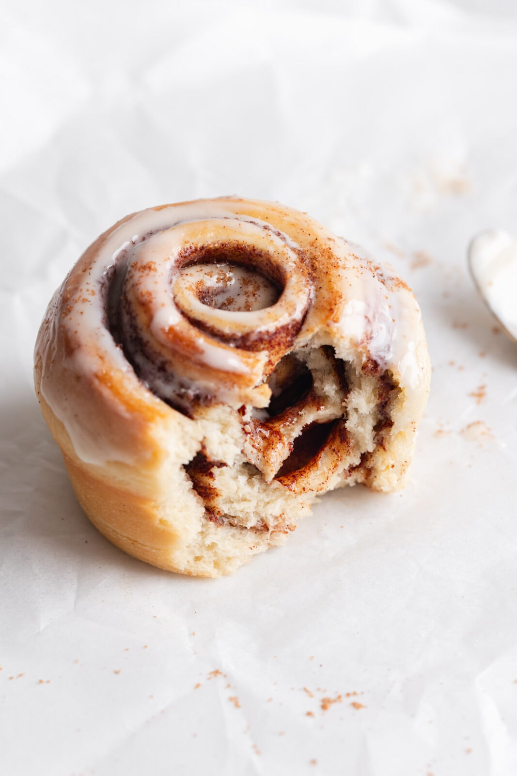 single cinnamon roll with a bite taken out